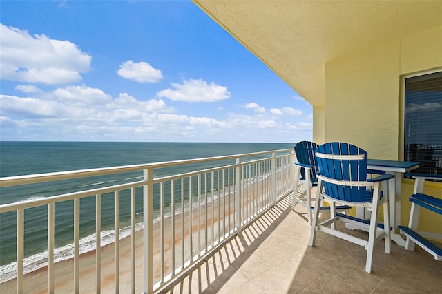 balcony featuring a view of the beach and a water view