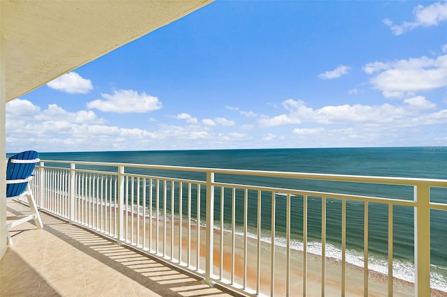 balcony featuring a beach view and a water view