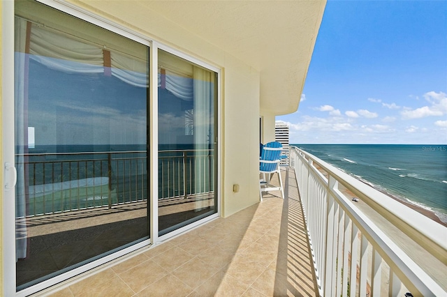 balcony featuring a view of the beach and a water view