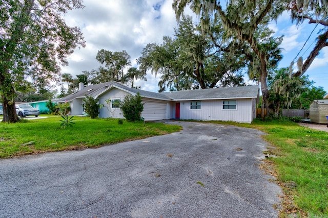 ranch-style home featuring a garage and a front lawn