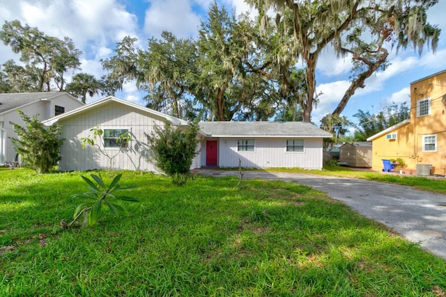 single story home featuring cooling unit and a front yard