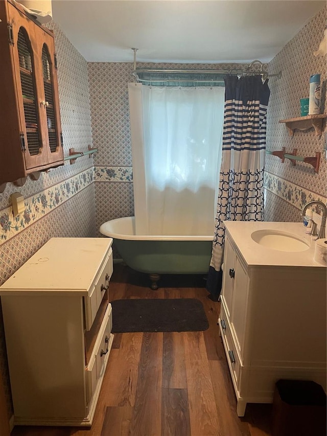 bathroom with hardwood / wood-style floors, vanity, shower / tub combo with curtain, and tile walls