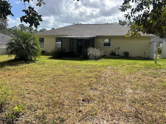 rear view of property with a yard and cooling unit