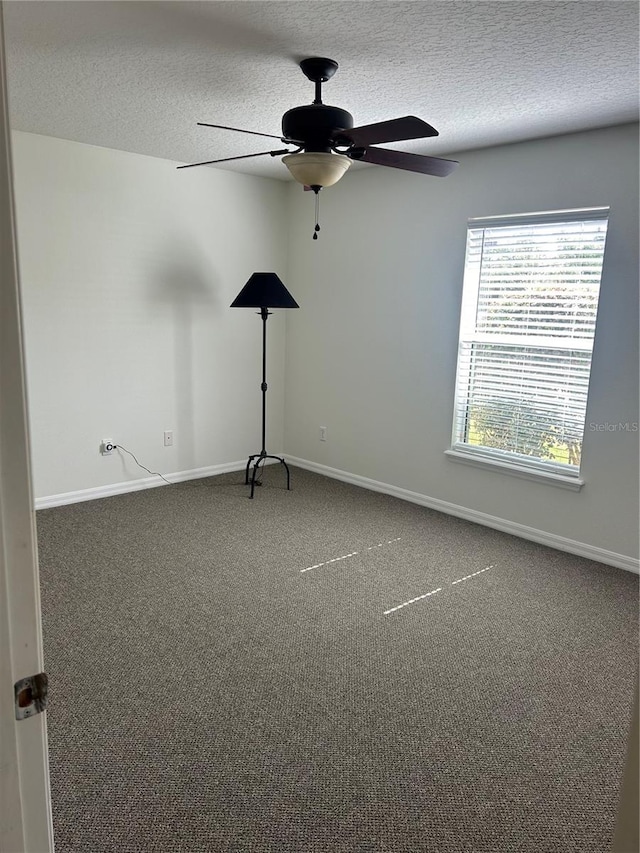 carpeted spare room with ceiling fan and a textured ceiling