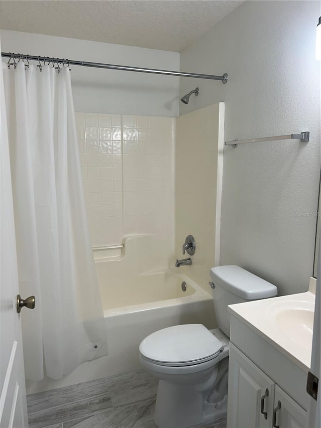 full bathroom featuring vanity, shower / tub combo, toilet, and a textured ceiling