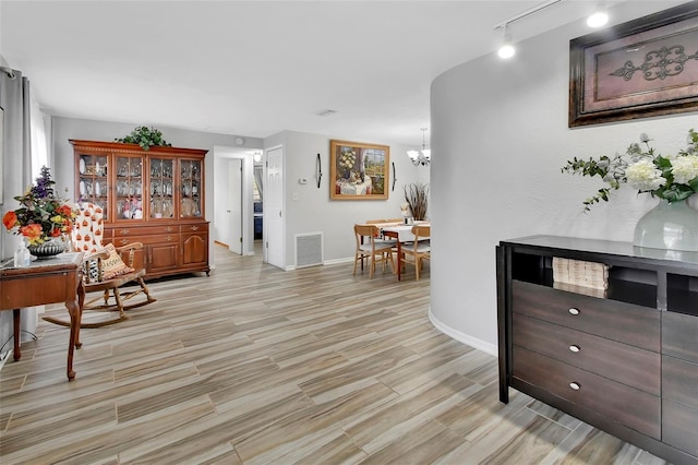 living area featuring rail lighting and a notable chandelier