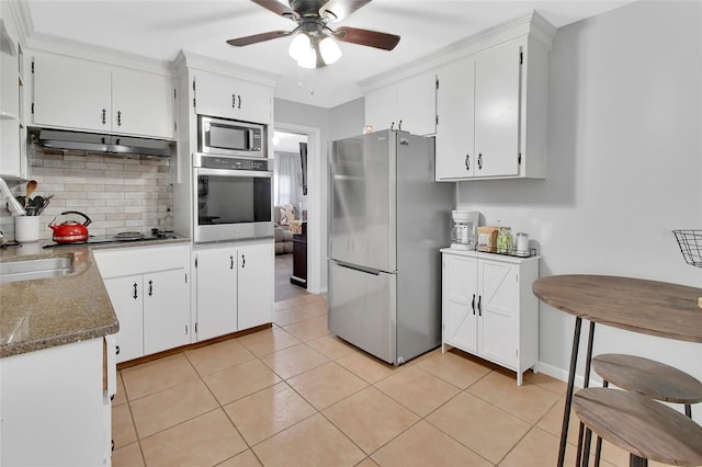 kitchen featuring white cabinets, appliances with stainless steel finishes, tasteful backsplash, and light tile patterned floors