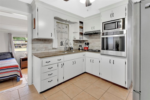 kitchen with sink, white cabinetry, tasteful backsplash, appliances with stainless steel finishes, and dark stone counters