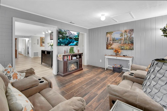 living room featuring ornamental molding, a fireplace, and hardwood / wood-style floors