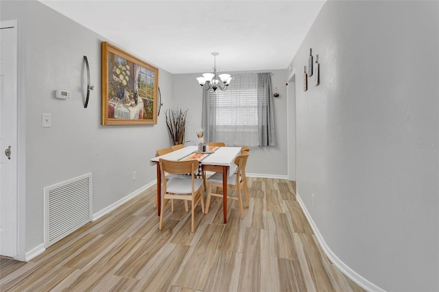 dining area featuring light hardwood / wood-style floors and a chandelier