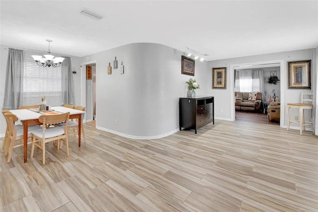 dining area featuring light hardwood / wood-style floors and a notable chandelier