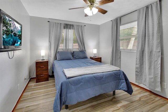 bedroom with multiple windows, ceiling fan, and light hardwood / wood-style flooring