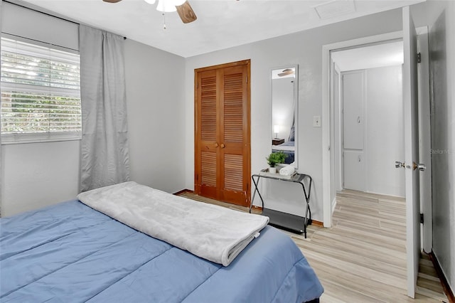 bedroom with light hardwood / wood-style flooring, a closet, and ceiling fan