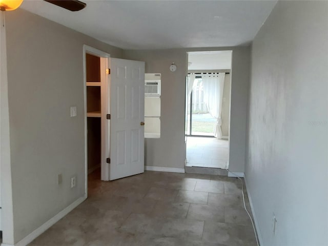 interior space with a wall mounted AC, ceiling fan, and a walk in closet