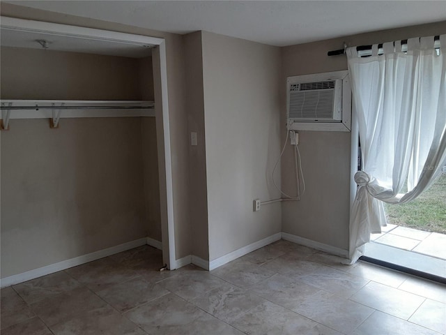 unfurnished bedroom featuring a wall mounted AC and a closet