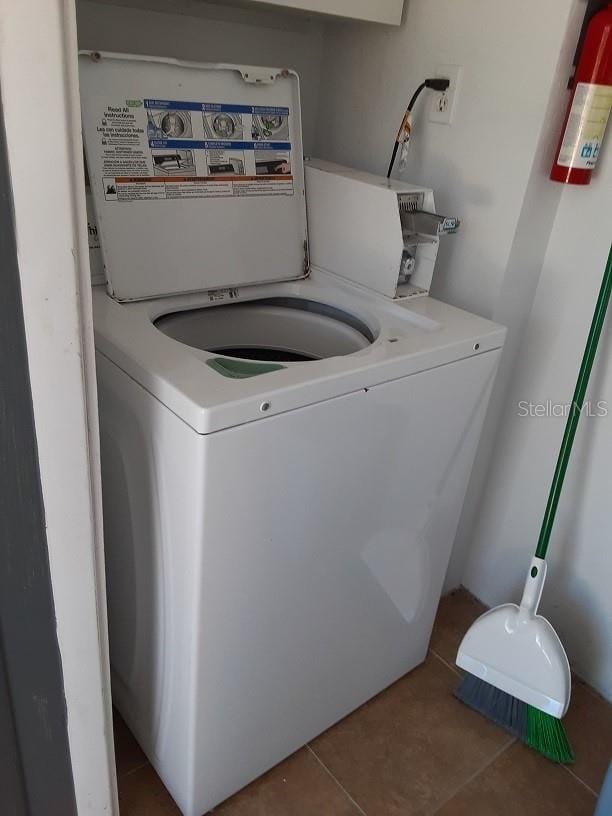 clothes washing area featuring tile patterned floors and washer / clothes dryer