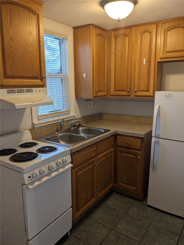 kitchen with dark tile patterned flooring, white appliances, sink, and ventilation hood