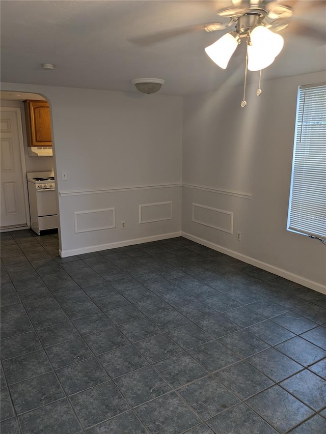 spare room featuring dark tile patterned flooring and ceiling fan