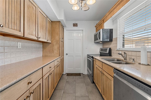 kitchen with sink, an inviting chandelier, decorative backsplash, light tile patterned floors, and appliances with stainless steel finishes