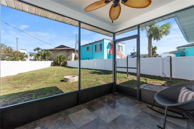 unfurnished sunroom featuring a wealth of natural light and ceiling fan