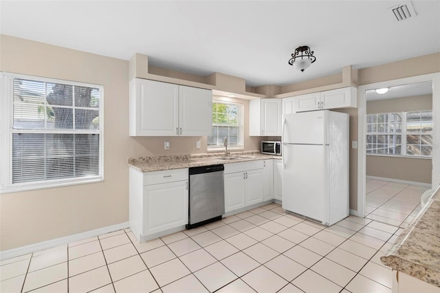 kitchen with white cabinets, sink, light tile patterned floors, and stainless steel appliances