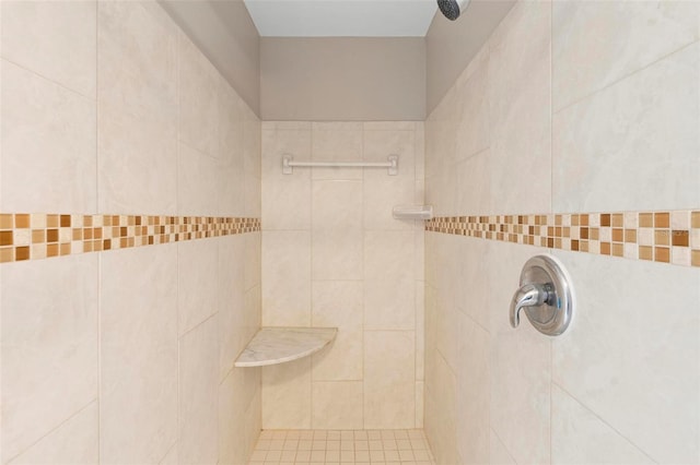 bathroom with tiled shower and tile walls