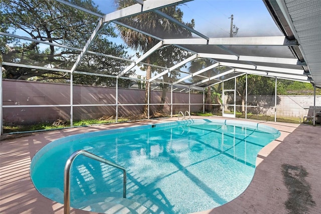 view of pool featuring glass enclosure and a patio area