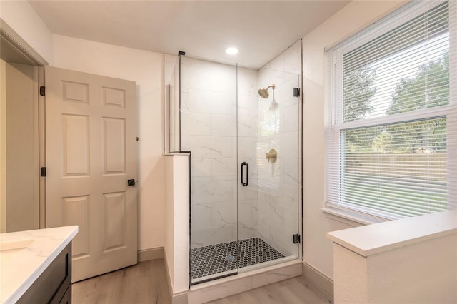 bathroom featuring wood-type flooring, vanity, and an enclosed shower