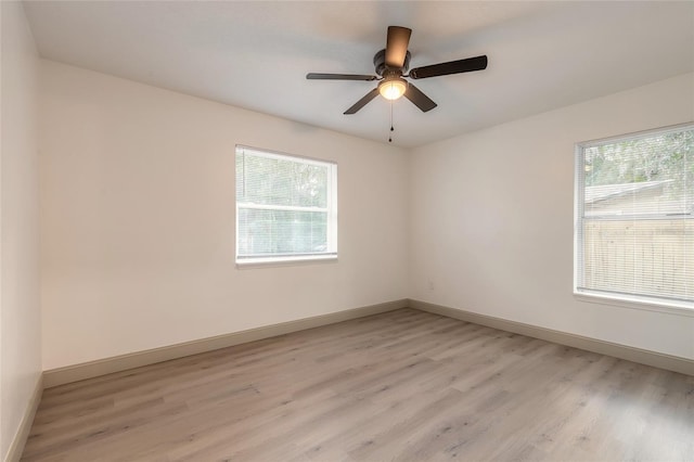 spare room featuring light hardwood / wood-style flooring, a wealth of natural light, and ceiling fan