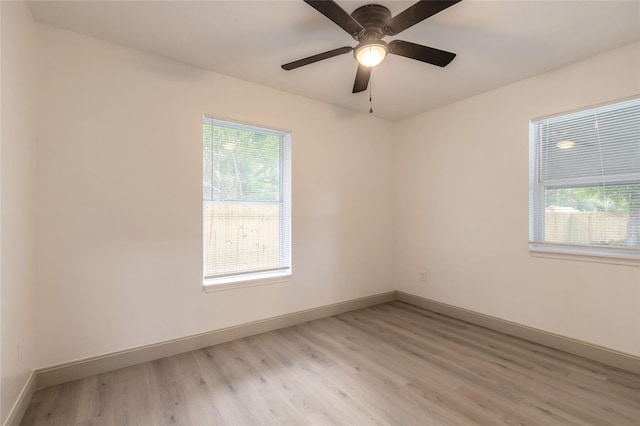 empty room with ceiling fan and light hardwood / wood-style flooring