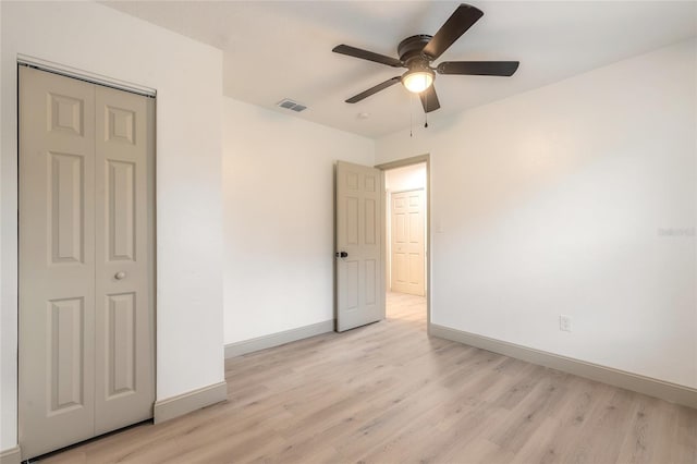 unfurnished bedroom with ceiling fan, a closet, and light hardwood / wood-style flooring