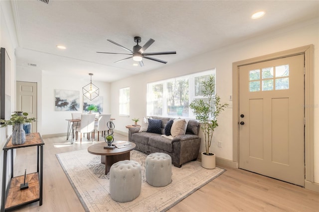 living room with ceiling fan, a healthy amount of sunlight, and light wood-type flooring