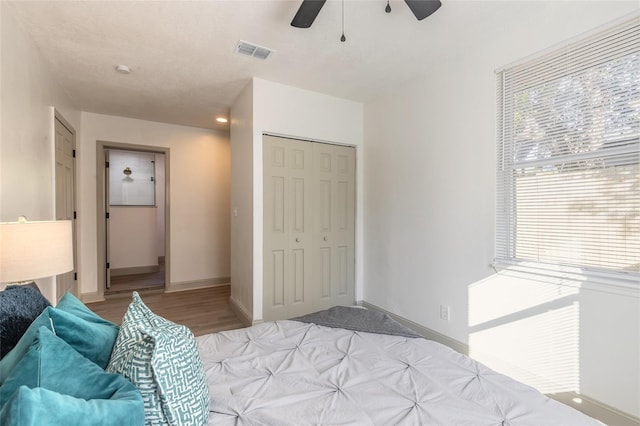 bedroom with light hardwood / wood-style flooring, a closet, and ceiling fan