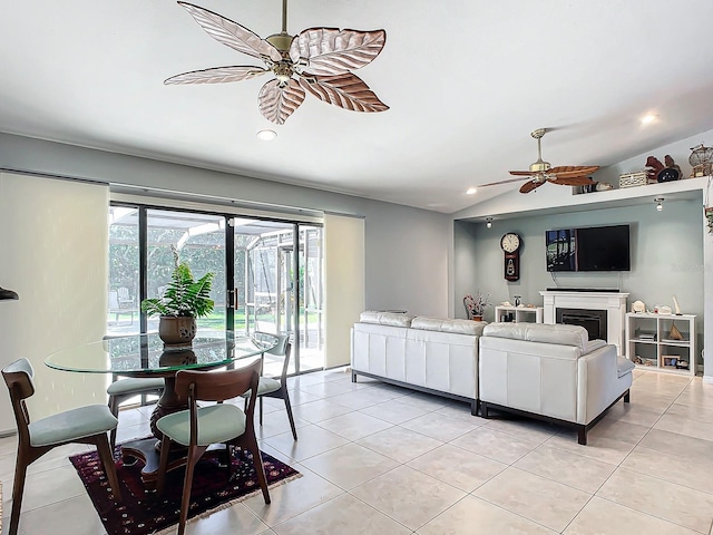 living room with ceiling fan, light tile patterned flooring, and vaulted ceiling