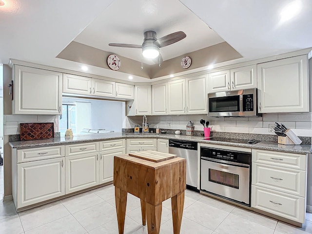 kitchen with white cabinets, backsplash, and stainless steel appliances