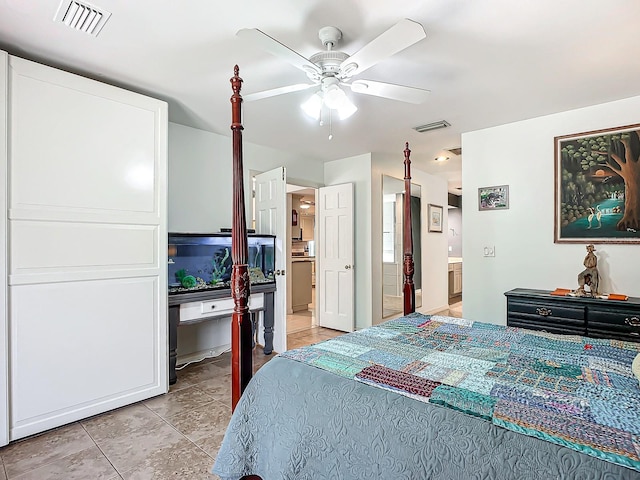 bedroom featuring ceiling fan, light tile patterned flooring, and ensuite bath