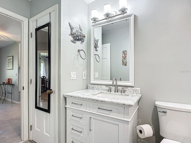 bathroom featuring tile patterned flooring, vanity, and toilet