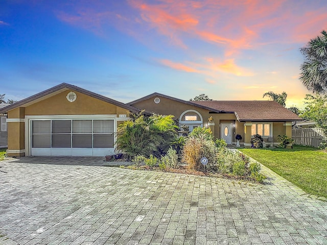 ranch-style home with a lawn and a garage