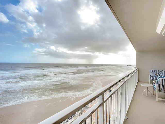 balcony featuring a water view and a view of the beach