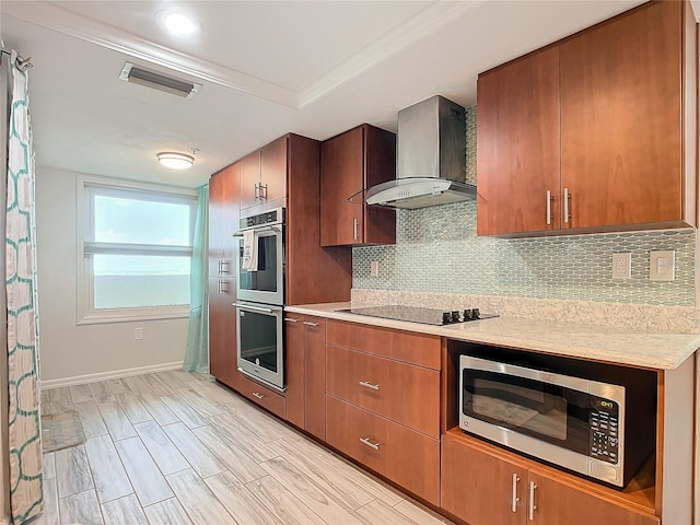 kitchen with crown molding, wall chimney exhaust hood, appliances with stainless steel finishes, tasteful backsplash, and light hardwood / wood-style floors