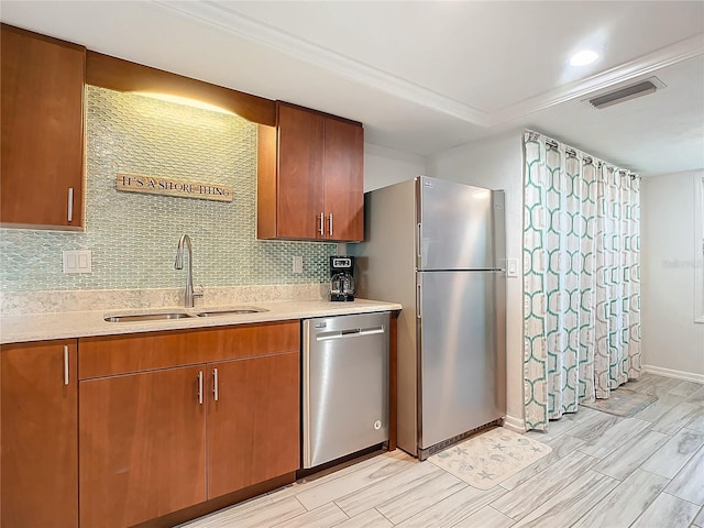 kitchen with tasteful backsplash, sink, stainless steel appliances, and light hardwood / wood-style flooring