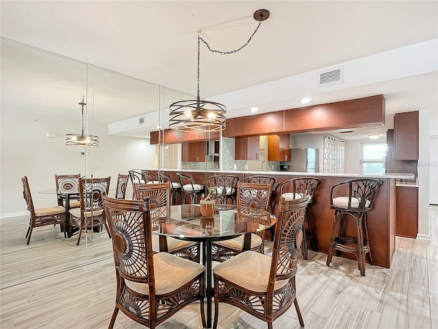 dining space with light wood-type flooring and an inviting chandelier