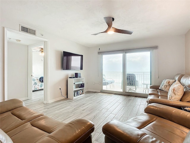 living room with light hardwood / wood-style flooring and ceiling fan