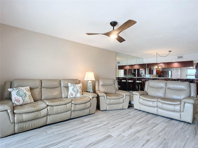 living room with ceiling fan and light hardwood / wood-style flooring