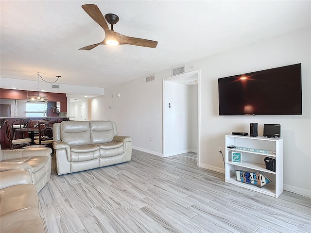 living room with ceiling fan and light hardwood / wood-style floors