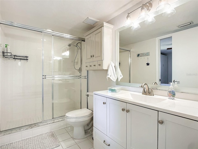 bathroom with tile patterned floors, toilet, vanity, and walk in shower