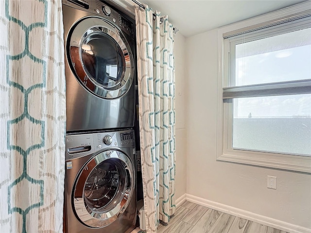 laundry area with light wood-type flooring and stacked washer / dryer