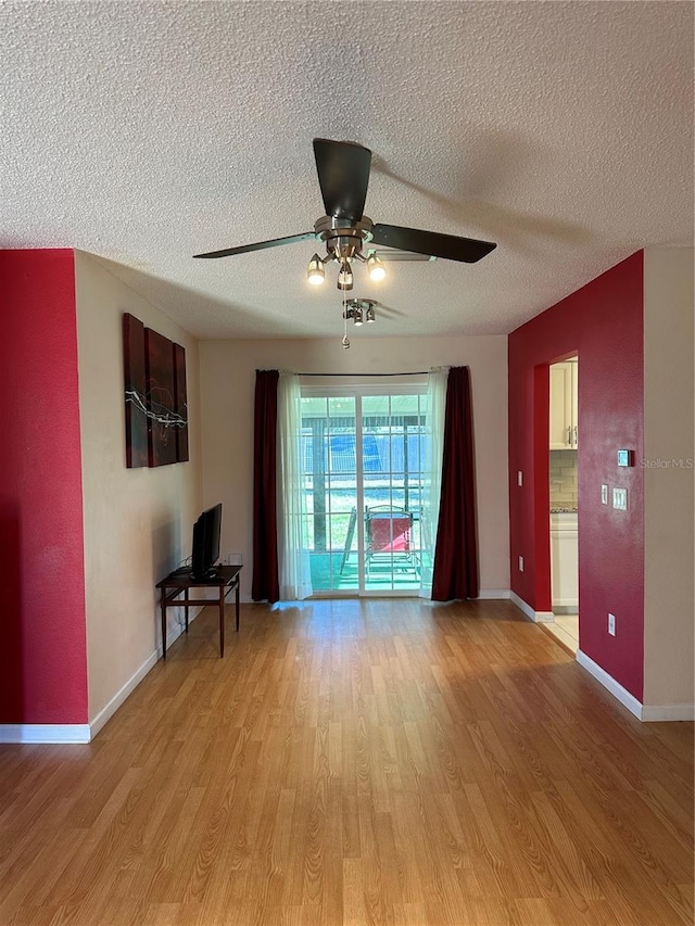 unfurnished room with a textured ceiling, light hardwood / wood-style flooring, and ceiling fan