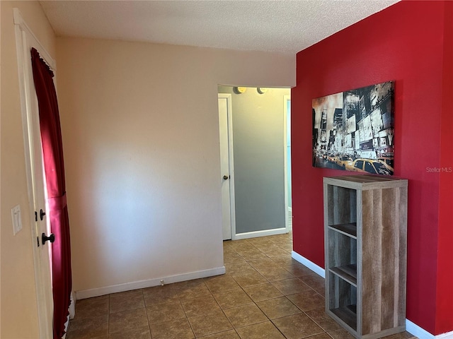 spare room with tile patterned flooring and a textured ceiling