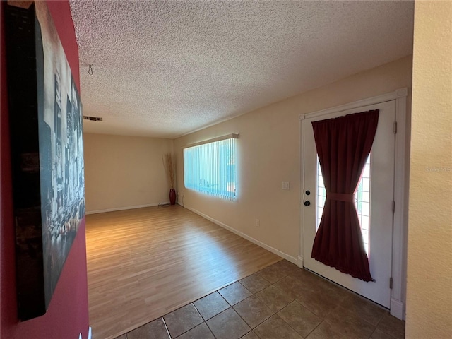 foyer with wood-type flooring and a textured ceiling